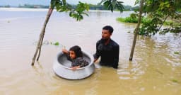 বন্যা পরিস্থিতি: মেয়েকে হাড়িতে বসিয়ে নিরাপদ আশ্রয়ের পথে বাবা